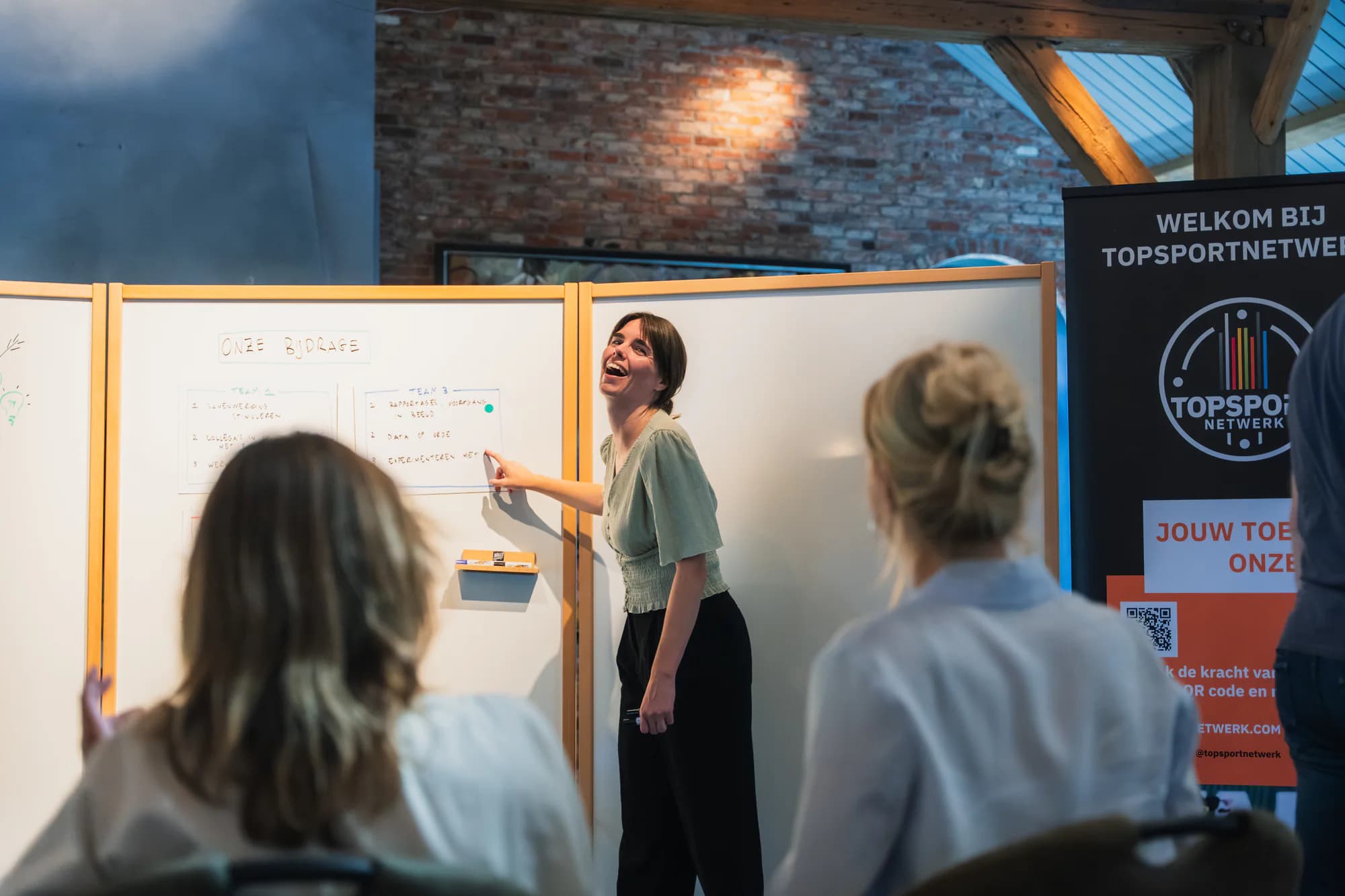 Facilitator die een sessie begeleidt met meerdere Walls